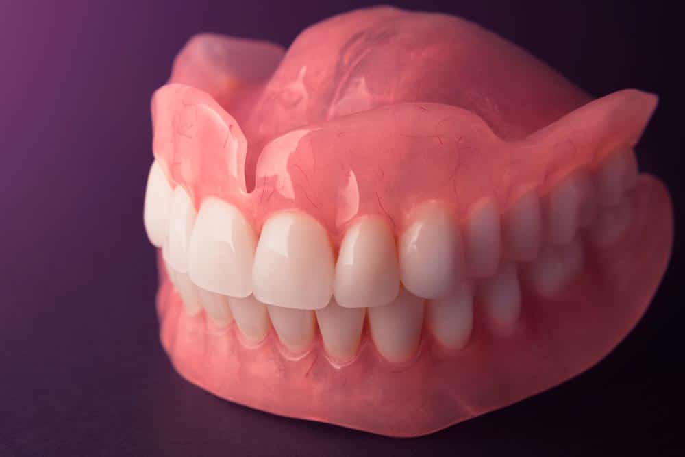 Acrylic Denture Prosthesis On A Black Background — Mid North Coast Dentures & Mouthguards in Port Macquarie, NSW